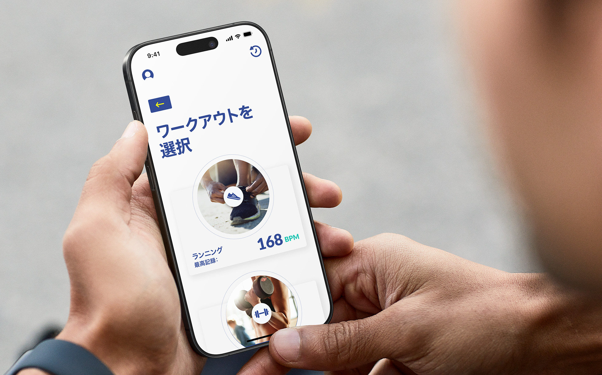 1人の人物がiPhoneでサンプルAppのSprint Pacerを使用している。画面に「Select workout」(ワークアウトを選択)オプションが表示され、過去のランニングの指標が示されている。