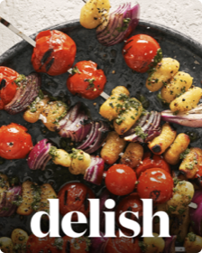 The cover of Delish featuring an image of grilled shish kabobs on a plate.